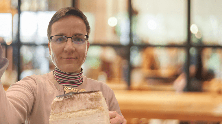 Veronika Valentová, R&D ředitelka a autorka metody Strategická eliminace, sedí v klidu v kavárně se zákuskem. Důkaz, že efektivní leadership a delegování zodpovědnosti uvolní čas na regeneraci.